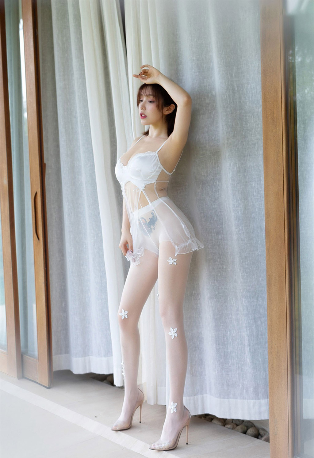 Dưới chiếc váy cưới nhẹ nhàng, mỏng manh và trong suốt của Hoàng Lạc Nhiên, kết hợp với tất silk mờ ảo.