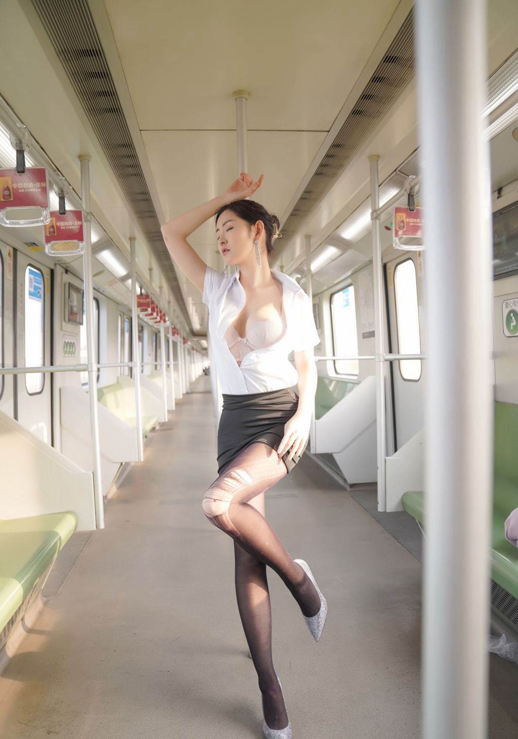 包臀裙を着た黒ストッキングの美女が地下鉄で色っぽいポーズで誘惑する画像